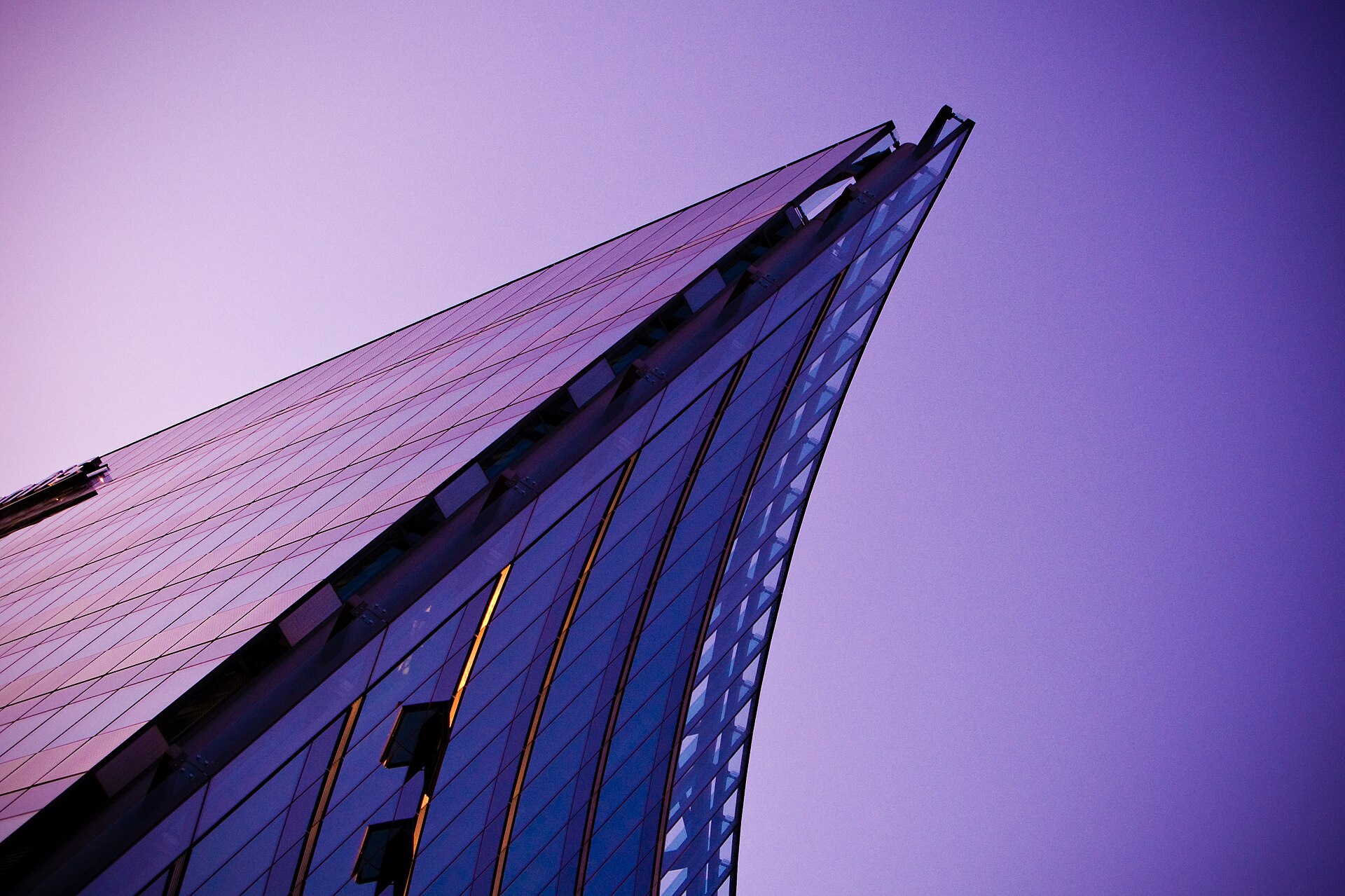Geometric glass architecture against an open sky